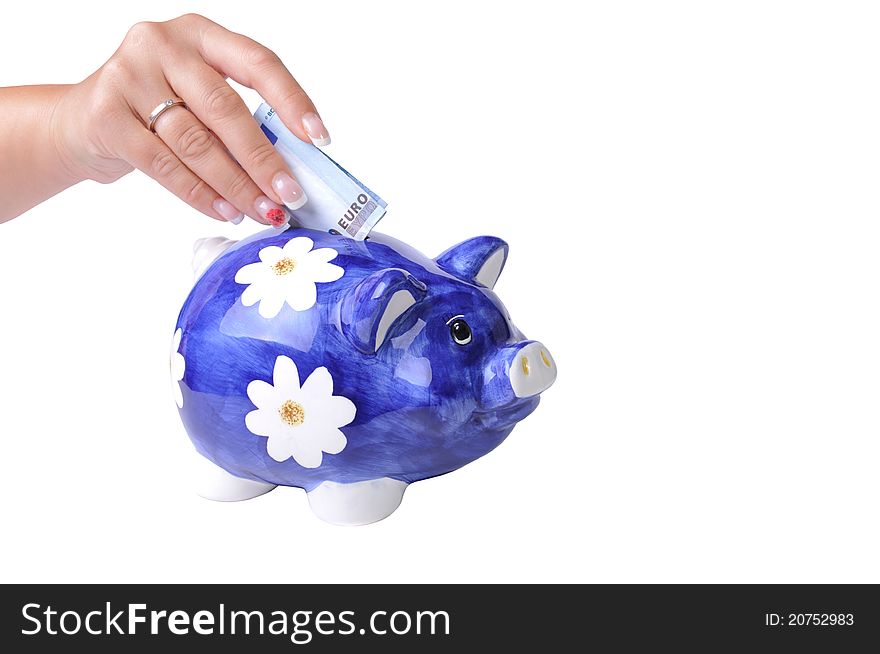 Woman hand putting 20 euros bill in piggy bank slot. Isolated on white with clipping path. Woman hand putting 20 euros bill in piggy bank slot. Isolated on white with clipping path