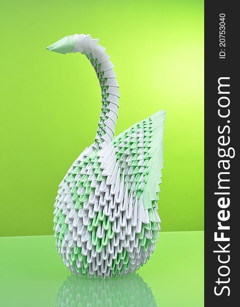 Origami. Figure of peacock on green background