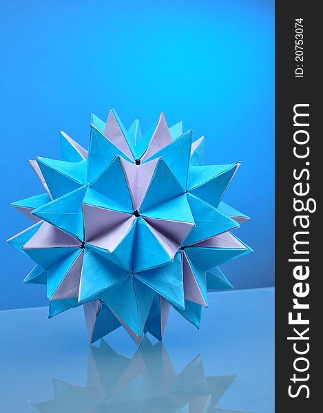 Origami ball on blue background