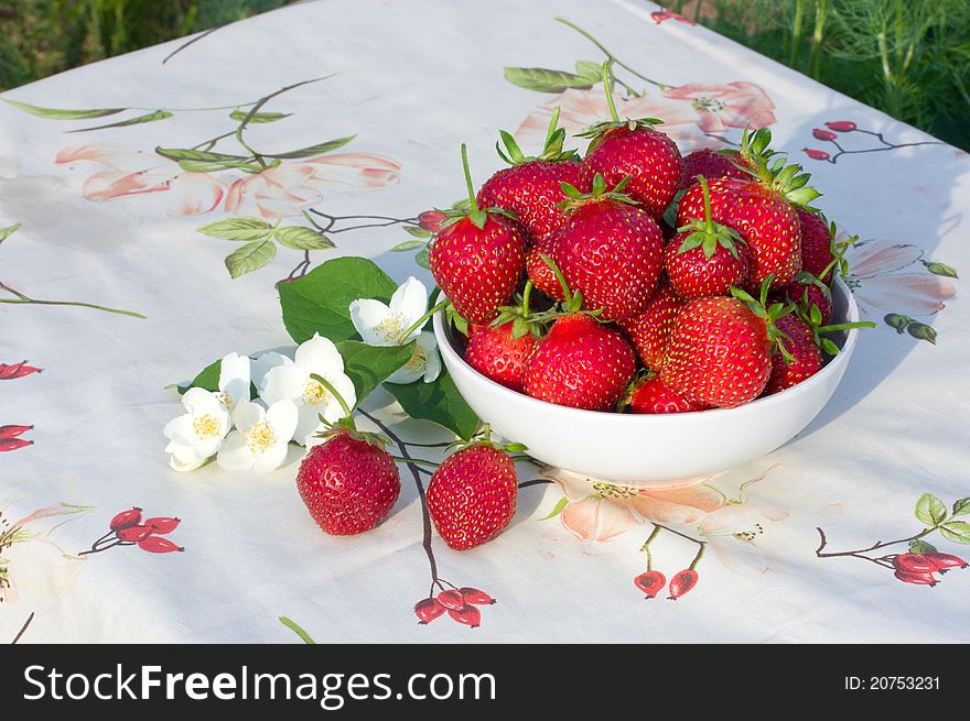Strawberries in a bowl on the tablecloth