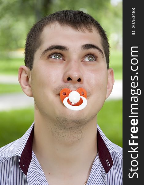 The man holds a dummy in a mouth. The man holds a dummy in a mouth