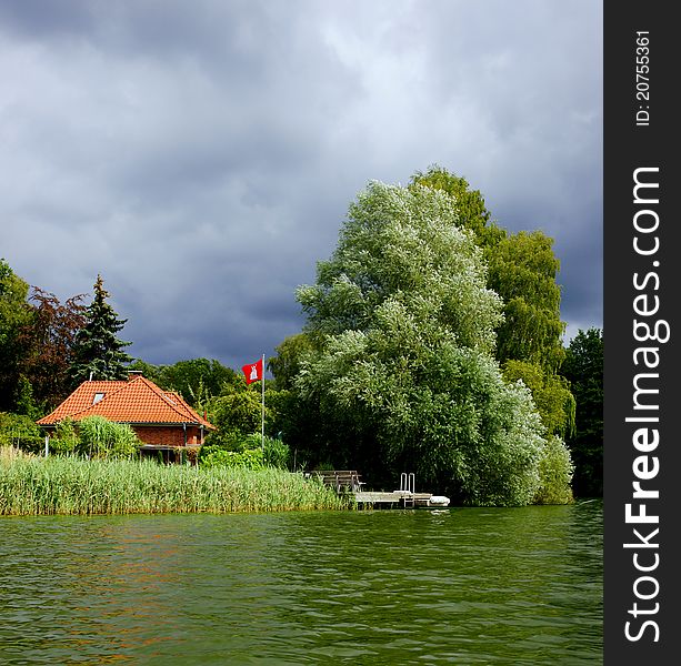 A storm is moving in on a house on Lake Ziegelsee near Moelln, Schleswig-Holstein (Germany). A storm is moving in on a house on Lake Ziegelsee near Moelln, Schleswig-Holstein (Germany).