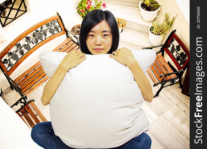 Young woman Dreaming of a new home. Holding a pillow in front of her