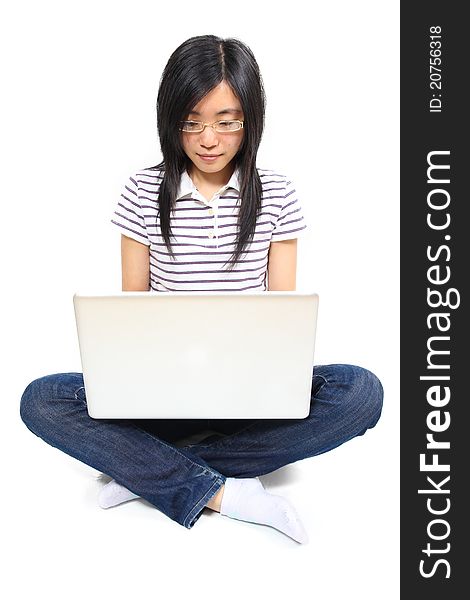 Young chinese woman sitting on the floor with laptop on the knees