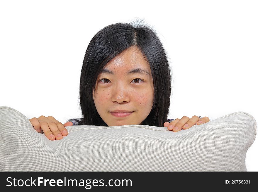 Young chinese woman hugging a pillow, Only head and hands visible