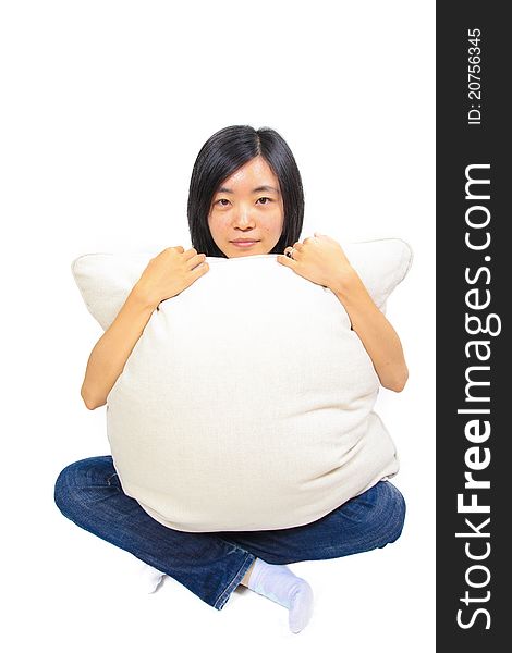 Young chinese woman sitting on the floor, hugging a pillow. Young chinese woman sitting on the floor, hugging a pillow