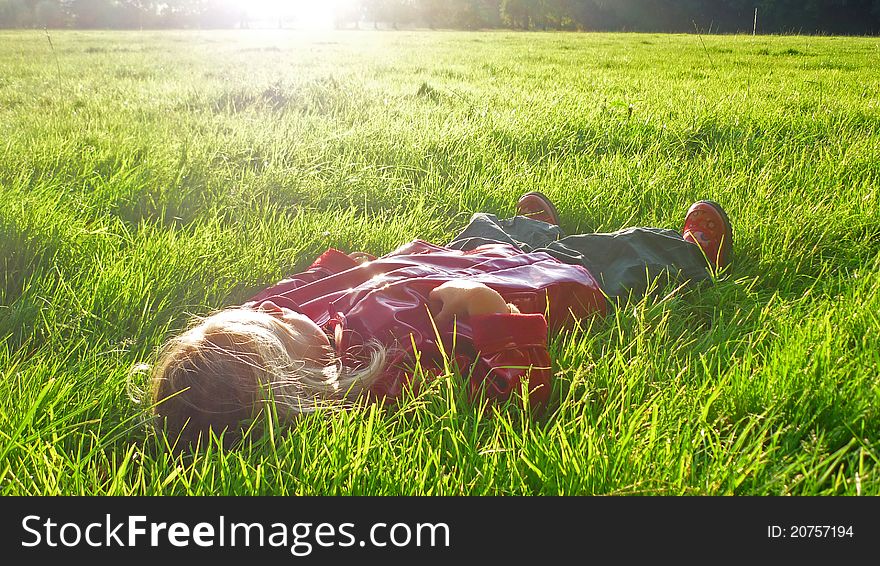 Little girl laying down in a grass field. Little girl laying down in a grass field