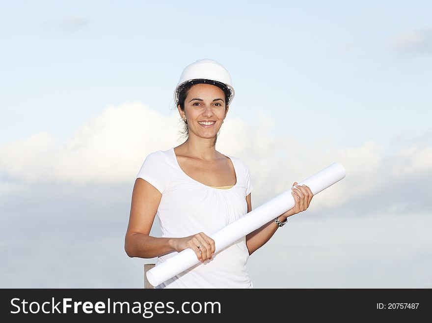 Engineer with a drawing in hand against blue sky