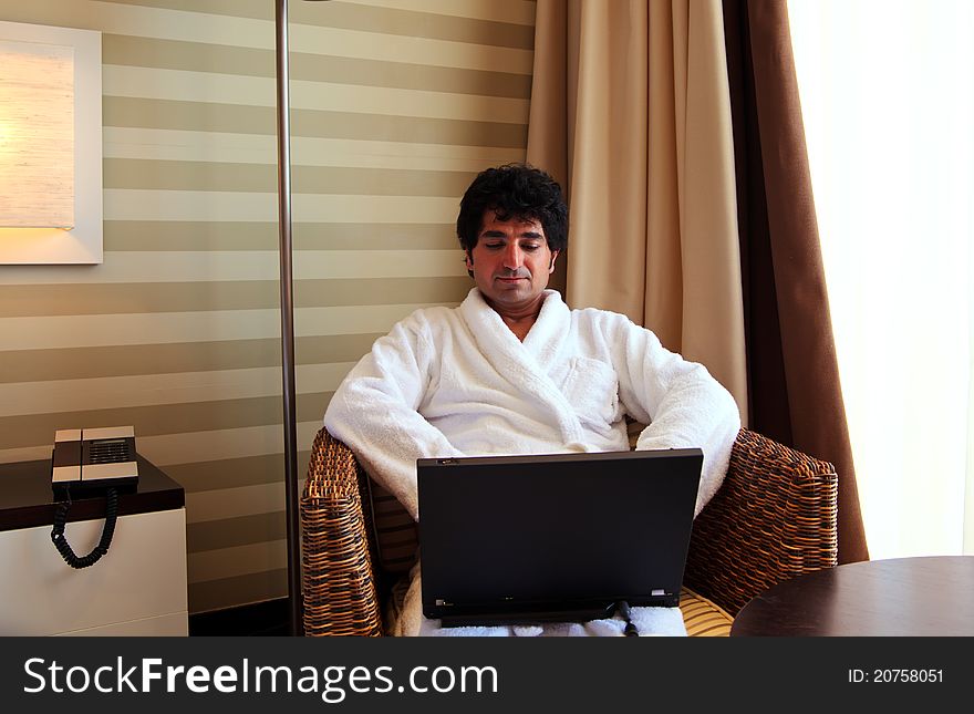 Man in bathrobe working with computer