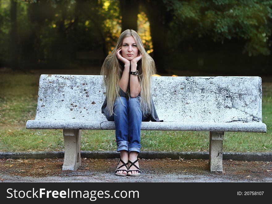 Young blong girl in autumn park in the evening