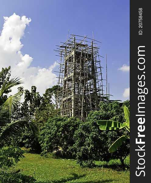 A large tower being constructed in a rural area of Asia. A large tower being constructed in a rural area of Asia