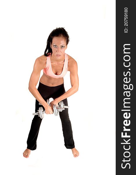 A young woman exercising with dumbbells, bending forwards, with bare feet for white background. A young woman exercising with dumbbells, bending forwards, with bare feet for white background.