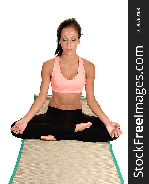 Woman sitting on the floor of a mat, relaxing in yoga with her eyes closed and her legs grossed, for white background. Woman sitting on the floor of a mat, relaxing in yoga with her eyes closed and her legs grossed, for white background.