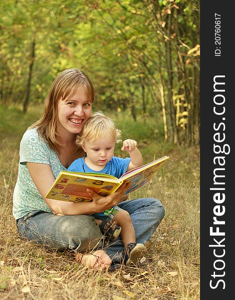 Mother and son reading book in summer nature. Mother and son reading book in summer nature