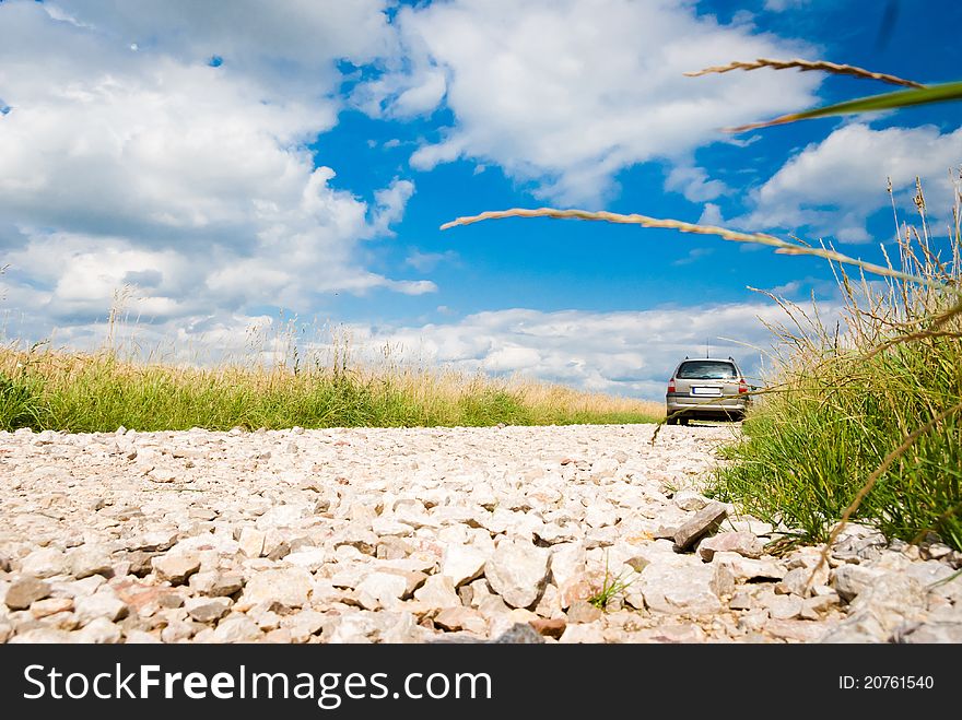 Country road, stone road under fluffy clouds, fall scenic road