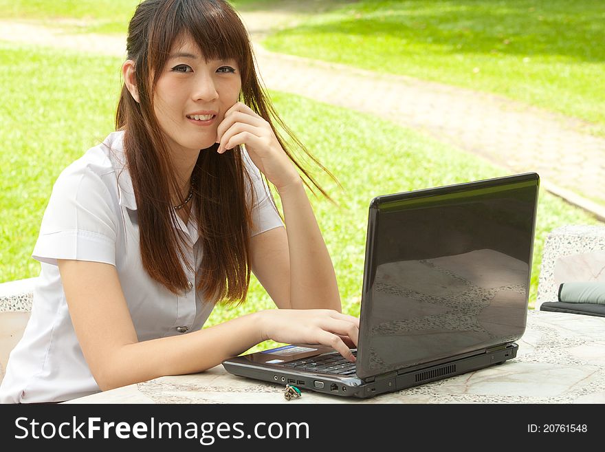 Asian young woman working with her notebook and smiling