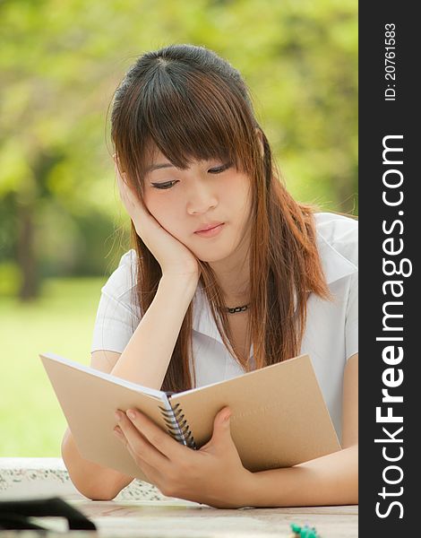 Young asian girl reading her notebook