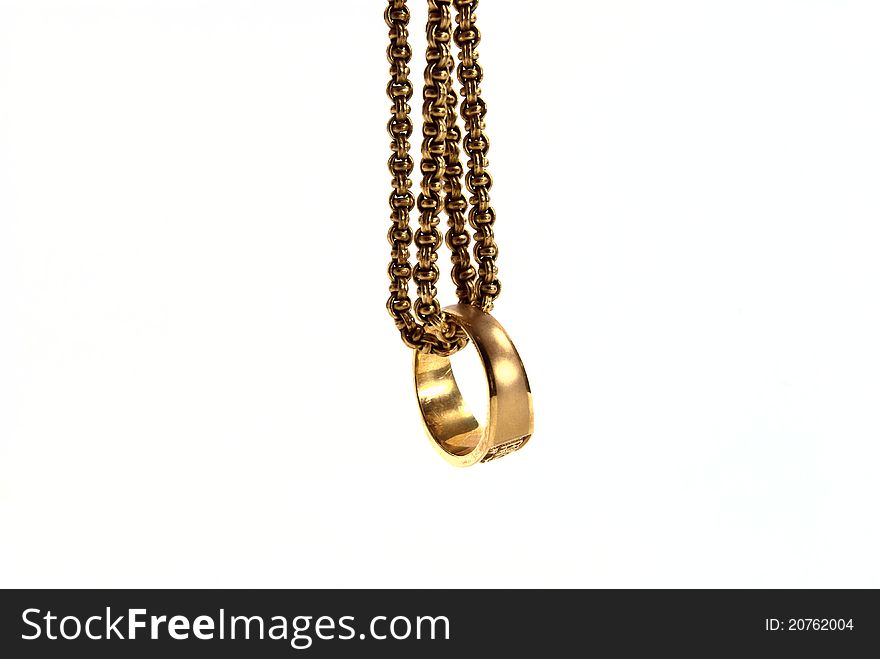 Gold ring with gold chain shot on white background.