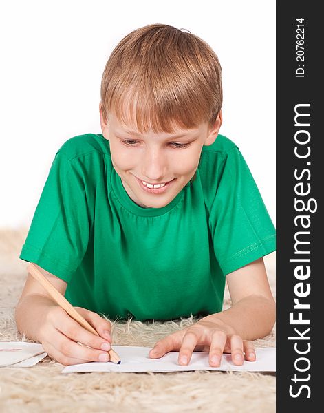 Portrait of nice boy drawing on carpet