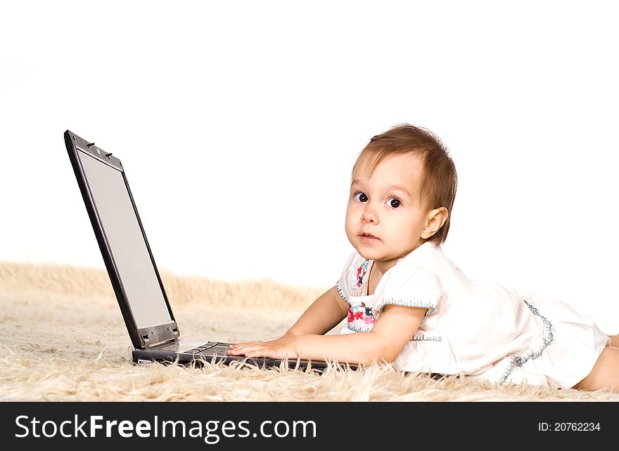 Cute little girl with laptop on a carpet. Cute little girl with laptop on a carpet