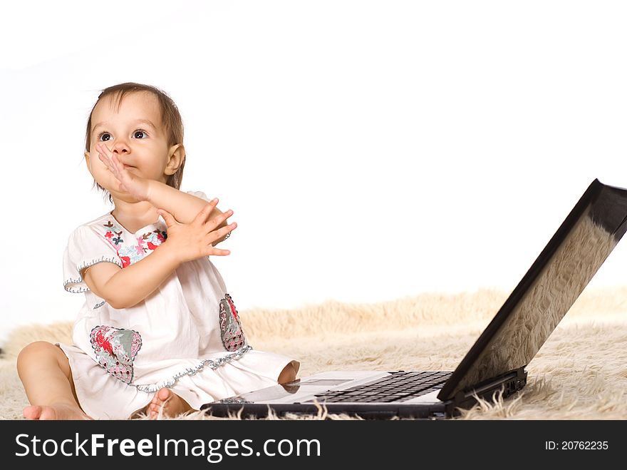 Cute little girl with laptop on a carpet. Cute little girl with laptop on a carpet