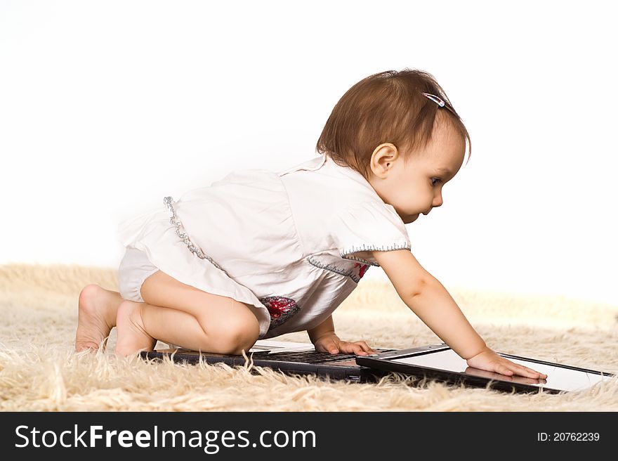 Cute little girl with laptop on a carpet. Cute little girl with laptop on a carpet