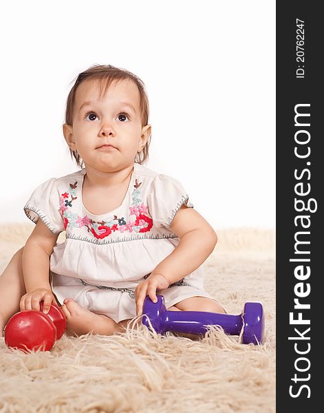 Little girl playing on a carpet on white. Little girl playing on a carpet on white