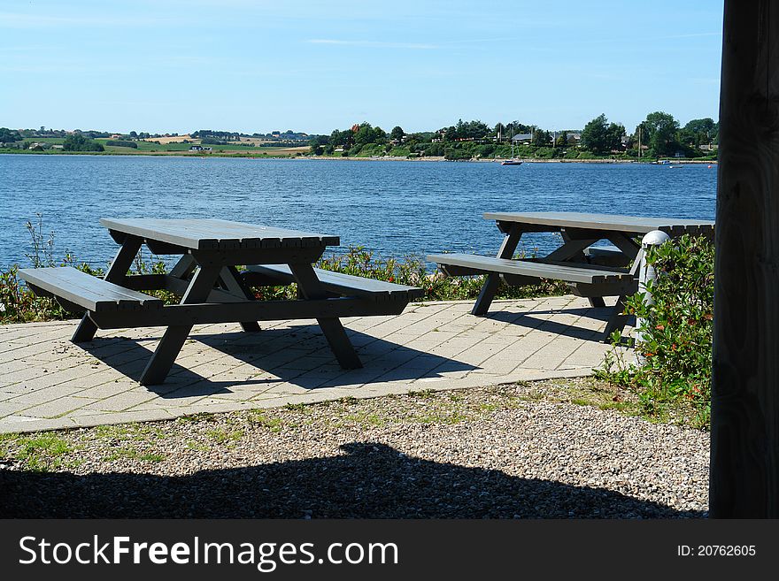 Attractive wooden picnic tables seating by the sea ocean with great landscape. Attractive wooden picnic tables seating by the sea ocean with great landscape