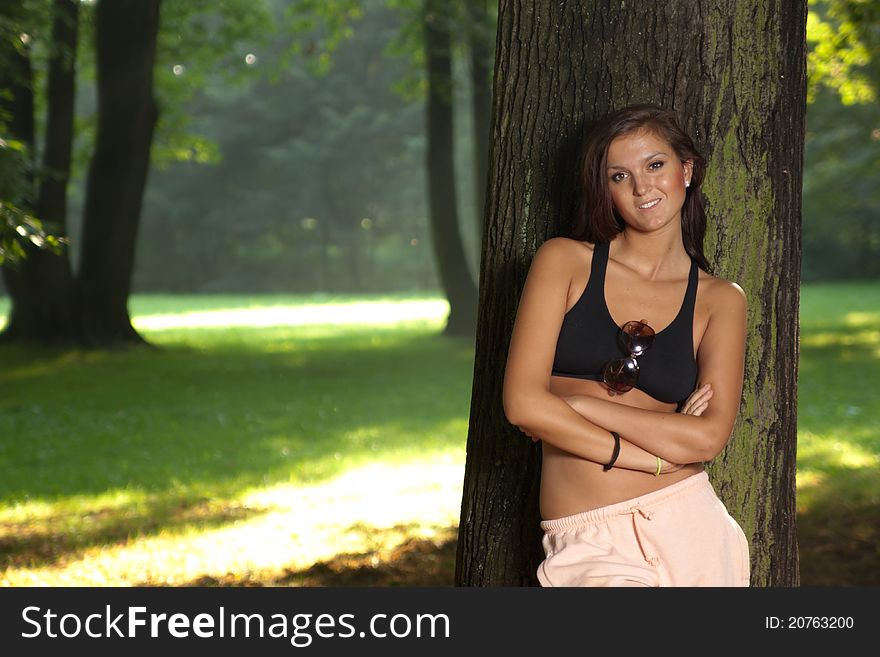 Attractive Young Woman Standing By The Tree