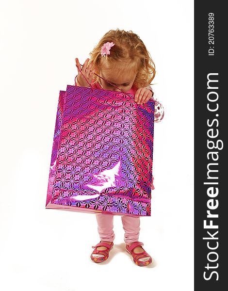 Little girl looking into a pink shiny shopping bag