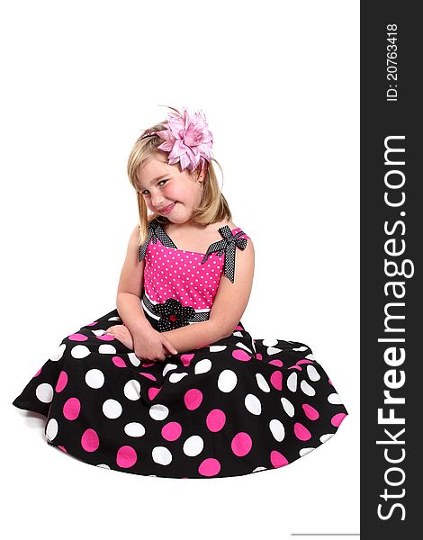 Little girl in a pretty pink dress with polka dots