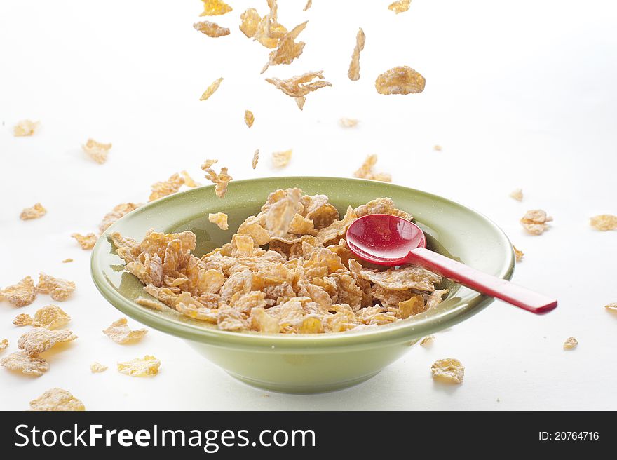 Cereal falling on the bowl with red spoon, healthy breakfast food