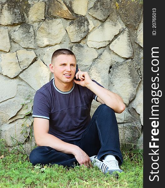 The young man with phone on picnic(park)