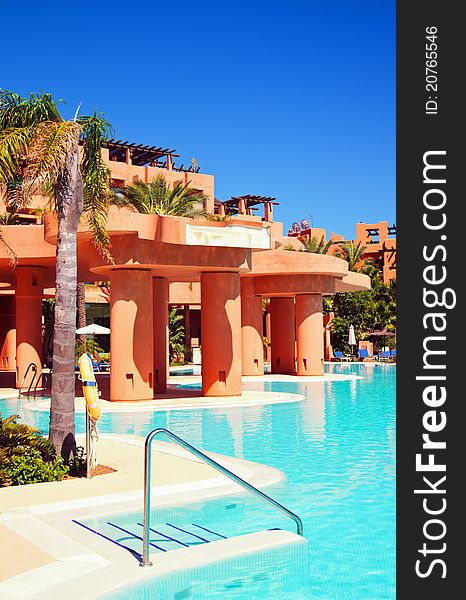 Swimming pool with palm trees and blue sky in luxury hotel. Swimming pool with palm trees and blue sky in luxury hotel