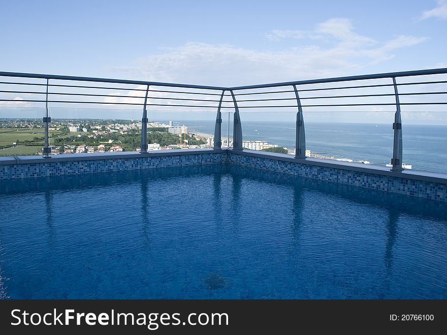 A beautiful swimming pool on the top of a building,with the view of the sea under it. A beautiful swimming pool on the top of a building,with the view of the sea under it