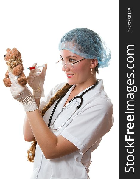 Beautiful doctor in a medical mask, sterile gloves takes blood from toys on a white background isolated. Beautiful doctor in a medical mask, sterile gloves takes blood from toys on a white background isolated