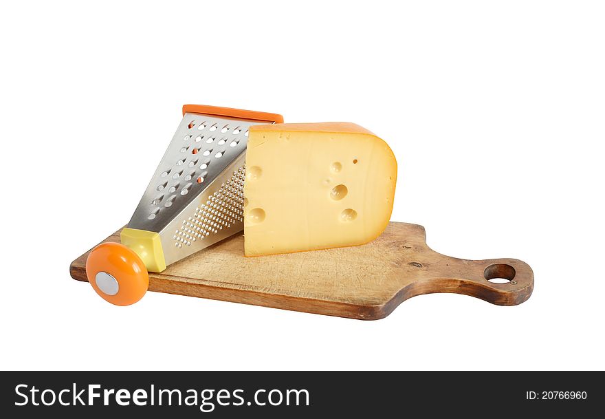 Piece of cheese near grater on wooden cutting board. Isolated on white with clipping path. Piece of cheese near grater on wooden cutting board. Isolated on white with clipping path