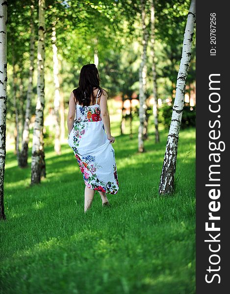 Beautiful woman walking on grass in birch grove . summer's day. Beautiful woman walking on grass in birch grove . summer's day.