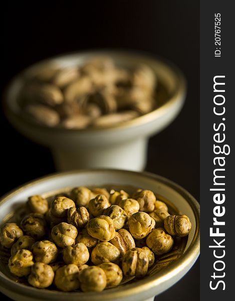 Chickpeas and pistacio in the bowl, black background. Chickpeas and pistacio in the bowl, black background