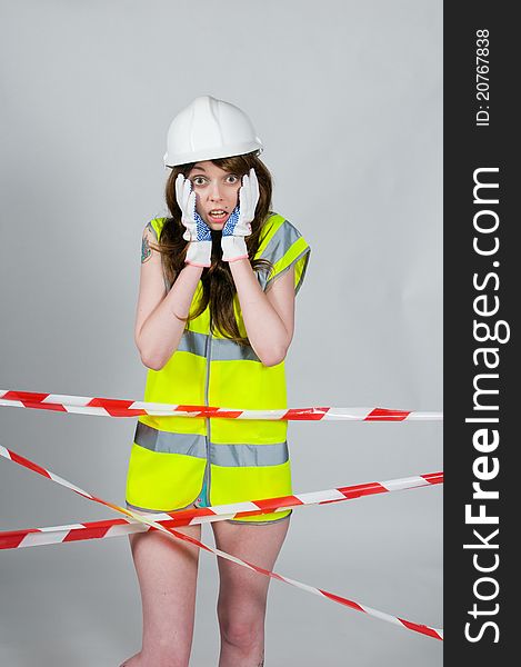 Girl wearing safety clothing behind barrier tape. Girl wearing safety clothing behind barrier tape.