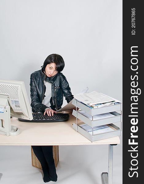 Girl sitting at desk on telephone reading papers. Girl sitting at desk on telephone reading papers