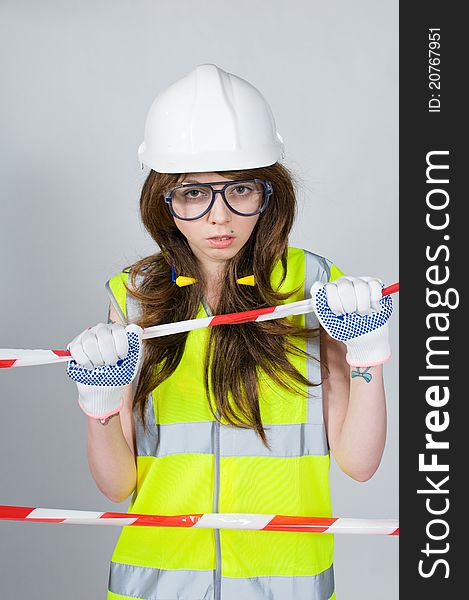 Girl wearing proctive clothing behind barrier tape. Girl wearing proctive clothing behind barrier tape
