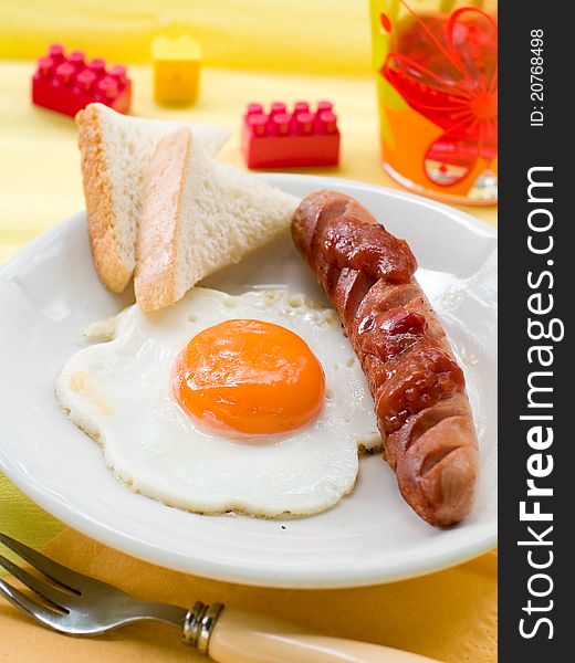 Breakfast of eggs, sausages, toast and juice for kids. Selective focus