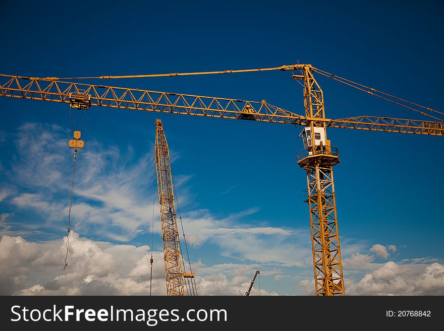 Working crane with blue sky and clouds