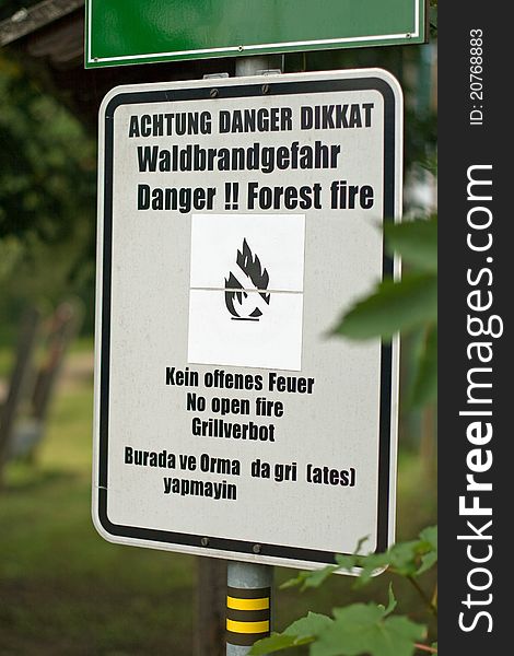 A metal sign that says Danger!! Forest fire in English, in German and in Turkish. A metal sign that says Danger!! Forest fire in English, in German and in Turkish