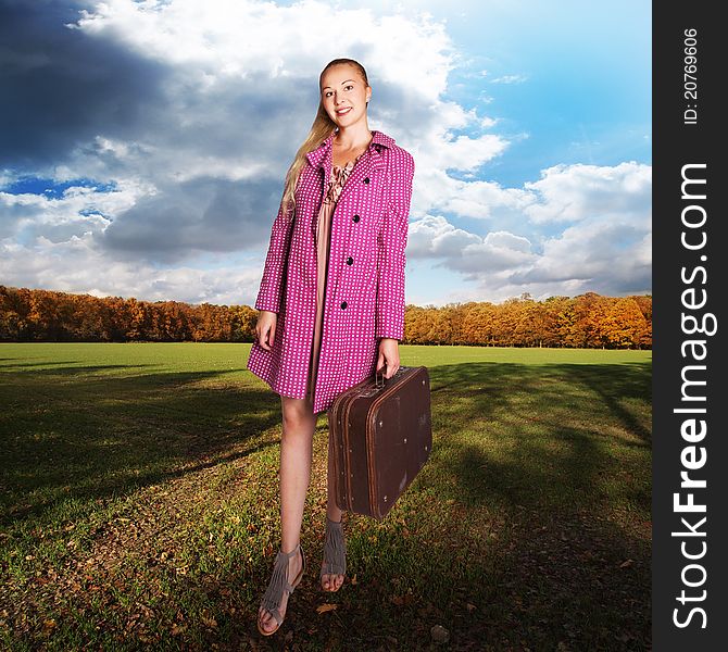 girl with vintage suitcase on field