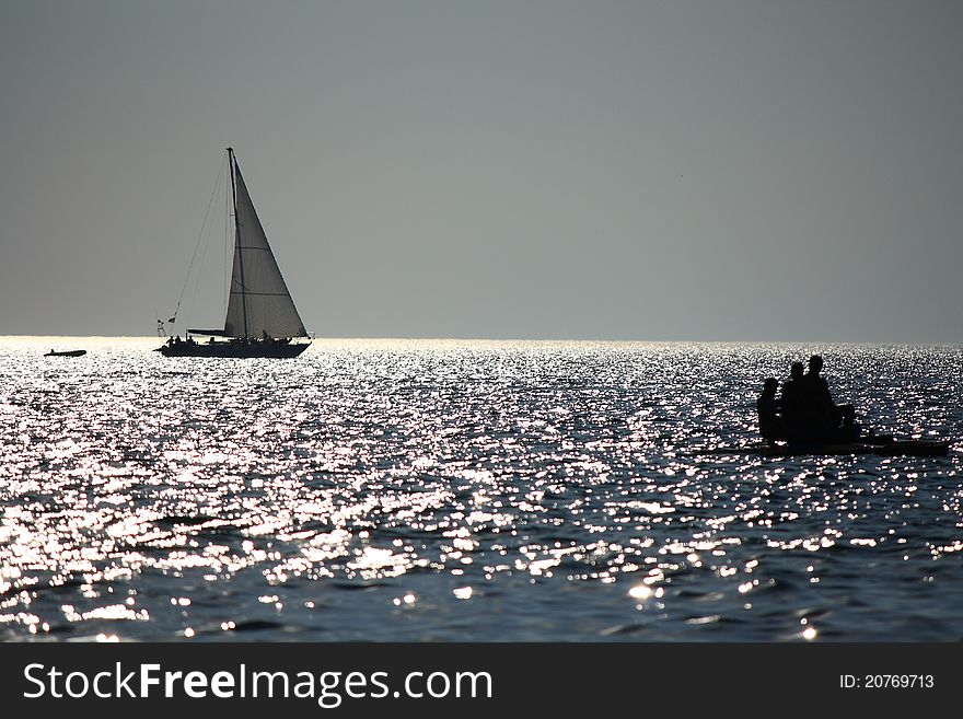 At this fografii depicts a sailboat at sunset.