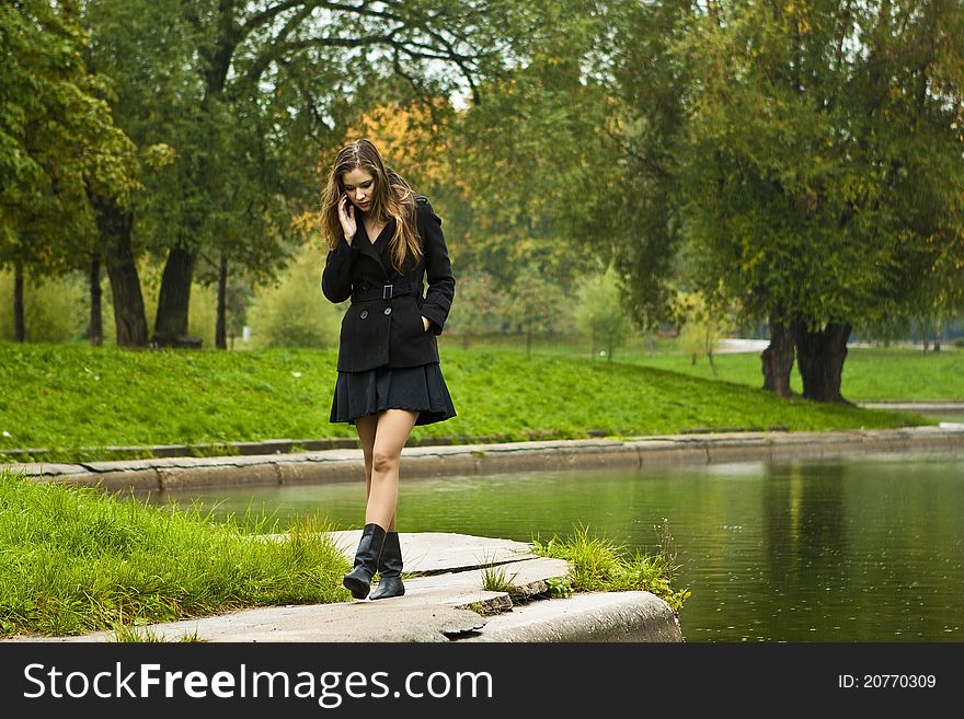 Beautiful girl walks in the park in autumn