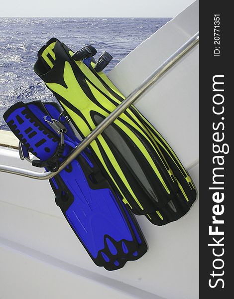 Scuba fins in a storage rack on the back of a boat
