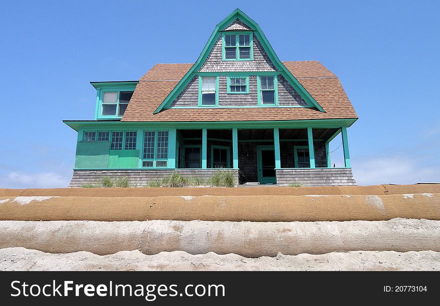 Victorian home on the beach surrounded with sandbags. Victorian home on the beach surrounded with sandbags.